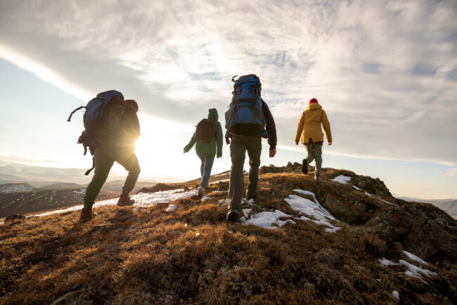 Group,Of,Four,Hikers,With,Backpacks,Walks,In,Mountains,At 6 Tips for Hiking with—and without—Back Pain