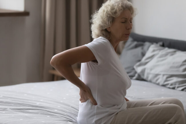 Unhappy,Frustrated,Middle,Aged,Woman,Touching,Back,Rubbing,Stiff,Muscles,